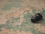 black toy car on world map paper